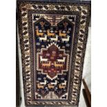 A Baluchi rug, the central panel set with stylised animal motifs on a blue and red ground,