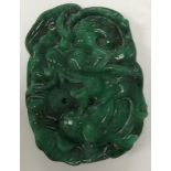 A Chinese carved green jade pendant with dragon decoration, 5 cm x 3.