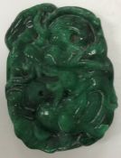 A Chinese carved green jade pendant with dragon decoration, 5 cm x 3.