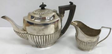 An Edwardian silver teapot with half reeded decoration and ebonised handle and finial (by Henry