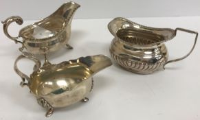 A Victorian silver sauce boat with scrolling handle and raised on three shell feet (by Charles