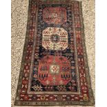 A Persian rug, the central panel set with three repeating medallions on a blue ground,