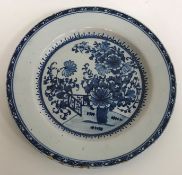 An early 19th Century Delftware plate decorated in the chinoiserie style with vase of flowers and