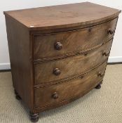 A Victorian mahogany bow fronted chest of three long drawers with turned knob handles,