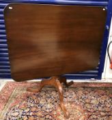 A 19th Century mahogany tea table, the rectangular tilt-top with rounded corners on a tripod base,