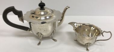 An Edwardian silver teapot with shaped rim, ebonised handles and finial,