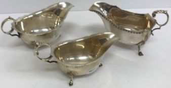 Three various silver sauce boats with scroll handles, each raised on three hoof feet,
