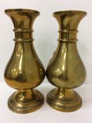 A pair of Chinese brass baluster shaped vases with ringed necks and flared rims raised on a