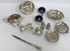 A collection of silver wares to include a pair of cauldron salts on three hoof feet with blue glass