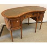 A 20th Century satinwood kidney-shaped writing table in the Sheraton manner,