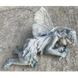 A cast metal figure of a fairy sleeping, with verdigirs style patination,