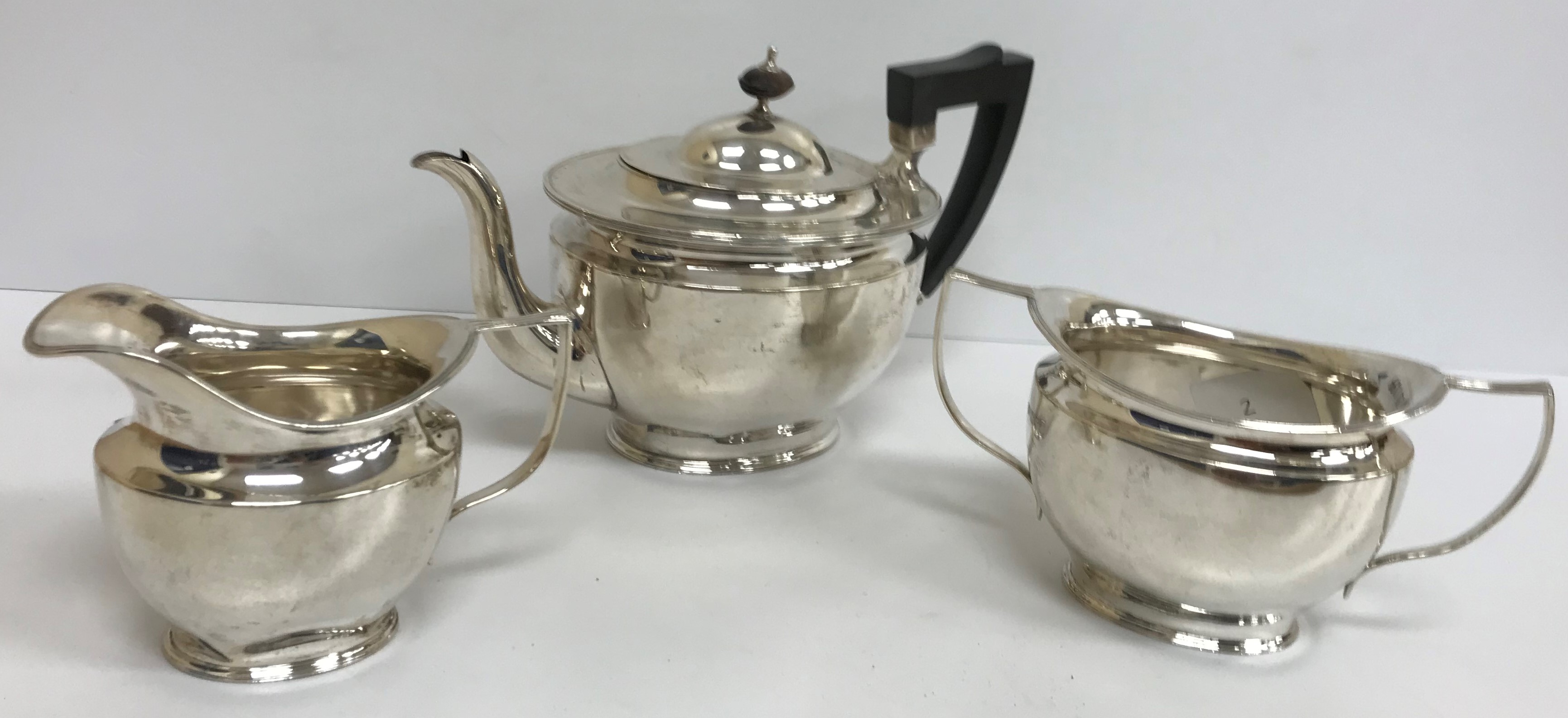 An Edwardian silver three piece tea set of simple form (by Goldsmiths & Silversmiths Company Ltd,