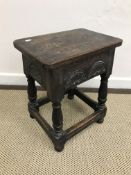 A joined oak stool in the 17th Century style, the single piece top over a lunette carved frieze,