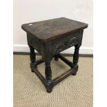 A joined oak stool in the 17th Century style, the single piece top over a lunette carved frieze,