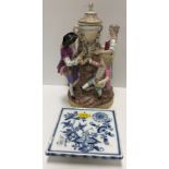 A late 19th Century Meissen figure group as a man and woman with seated child arranging a floral