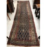 A Persian runner, the central panel set with stylised hook motif on a dark blue ground,