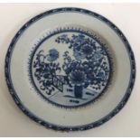 An early 19th Century Delftware plate decorated in the chinoiserie style with vase of flowers and