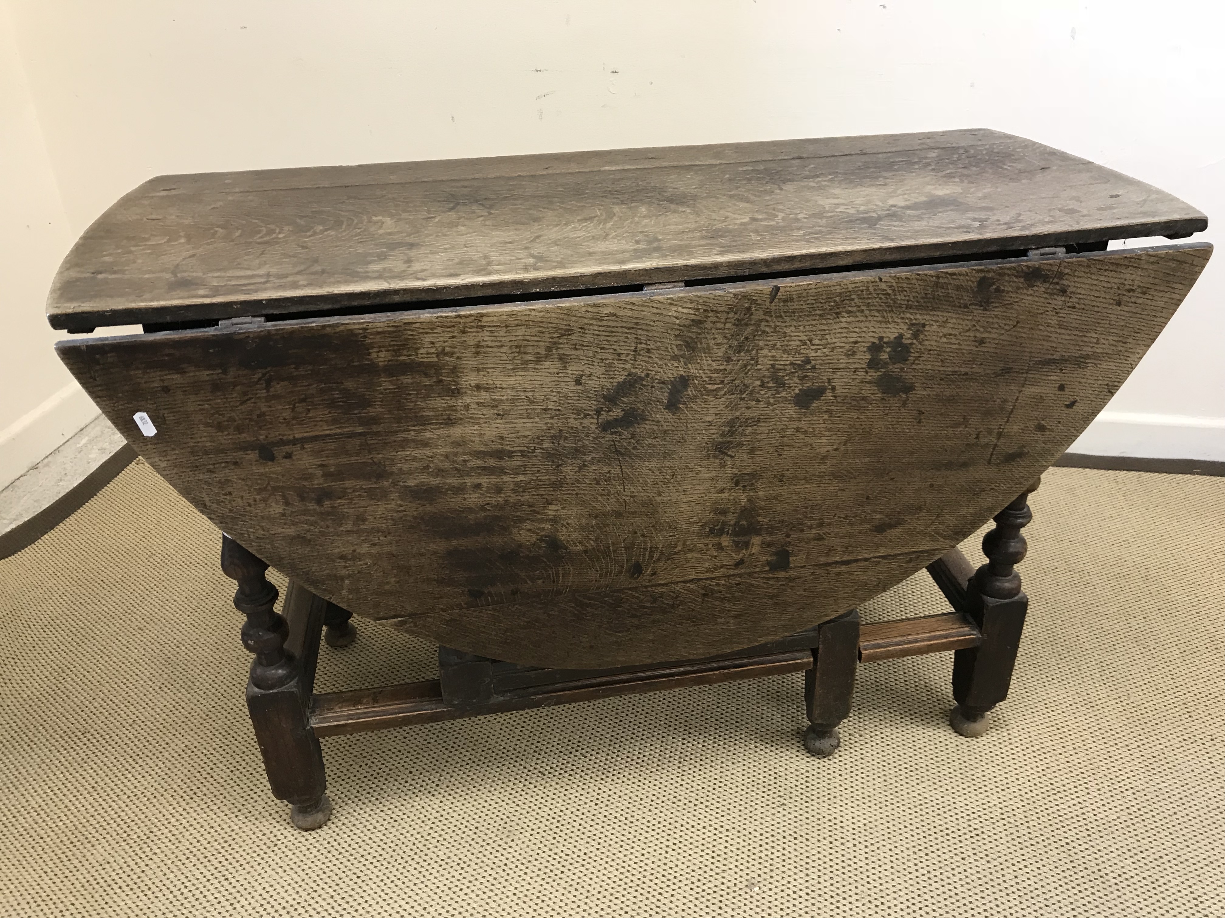An 18th Century oak oval gate-leg drop-leaf dining table with single end drawer on turned and