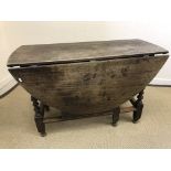 An 18th Century oak oval gate-leg drop-leaf dining table with single end drawer on turned and