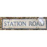 A painted metal street sign inscribed "Station Road" 99 cm x 23 cm