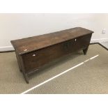 An 18th Century elm hutch of typical form, the single plank top carved with central stylised tulip,