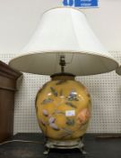 A pair of modern glass table lamps with reverse painting style decoration of fruit and cream shades