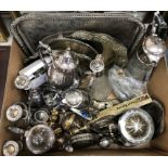 A box containing assorted silver plated wares to include claret jugs, teapots, candlesticks,