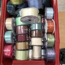 Two boxes of unused and part used reels of mainly satin ribbons of varying colours and widths
