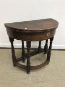 A 19th Century oak credence table of demi-lune form in the 17th Century manner,