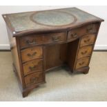 A mahogany serpentine fronted kneehole desk in the George III style,