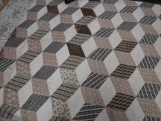 An early 20th Century tumbling blocks pattern quilt of large proportions in brown,