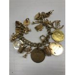 A 9 carat gold charm bracelet with various 9 carat gold and other charms,