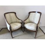A pair of early 20th Century French mahogany elbow chairs in the Empire taste,
