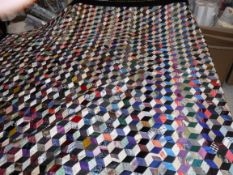 An early 20th Century silk and velvet tumbling blocks pattern patchwork quilt with purple velvet