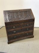 An 18th Century oak bureau with later carved decoration in the Gothic Revival taste,