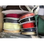 A box containing tulle ribbons of various widths, hat netting, string sequins,