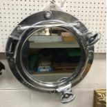 A modern chrome effect port hole style mirror,