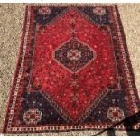 A Shriaz carpet, the central panel set with blue ground medallion on a red and blue ground,