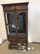 An early 20th Century oak display cabinet in the 17th Century style,