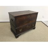 An 18th Century oak mule chest, the plain top opening to reveal a candle box with two drawers,