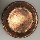 A Newlyn School copper dish of circular form by John Pearson with dot and inverted dot decoration