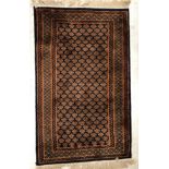 A Bokhara rug, the central panel set with repeating stylised motifs on a dark blue ground,