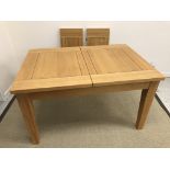 A modern oak extending dining table of plain form, with two leaves,