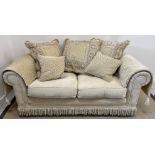 A pair of modern cream upholstered Chesterfield type two seat sofas and matching pouffe together