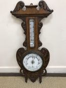 A circa 1900 carved oak cased aneroid barometer thermometer 85 cm high x 34 cm wide
