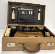An early 20th Century travelling vanity case with fitted interior containing ivorine mounted