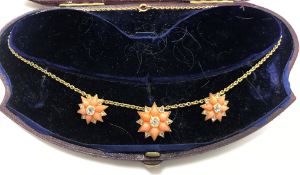 A circa 1900 pink coral and diamond flower head necklace, the central stone approximately 0.