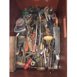 A box of various hand tools including bradle, planes, spanners,