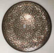 A Middle Eastern Islamic copper and white metal charger with all over floral and foliate decoration