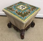A Victorian upholstered ottoman stool of tapered form raised on scrolling foliate carved base and